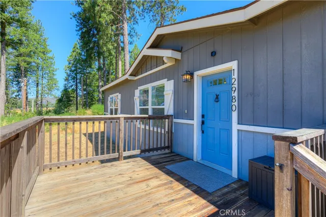 a balcony with wooden floor table and chairs