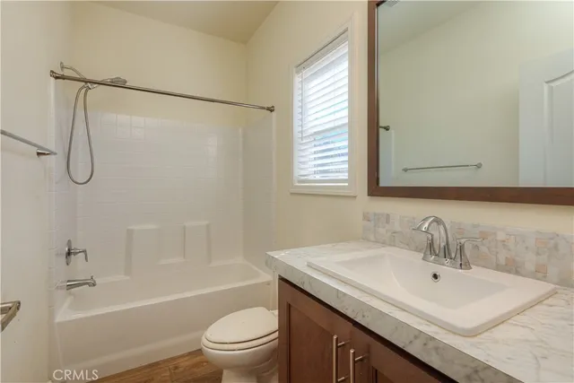 a bathroom with a sink toilet vanity and shower