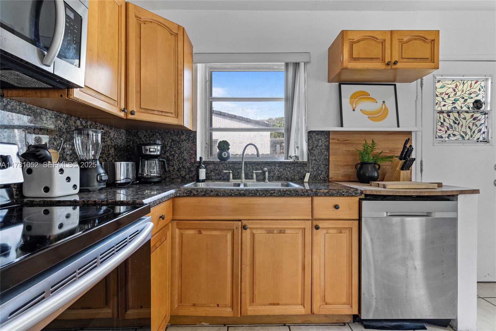 260 Northeast 45th Street Miami, FL 33137 - Photo 12 of 34 a kitchen with stainless steel appliances granite countertop a sink and cabinets