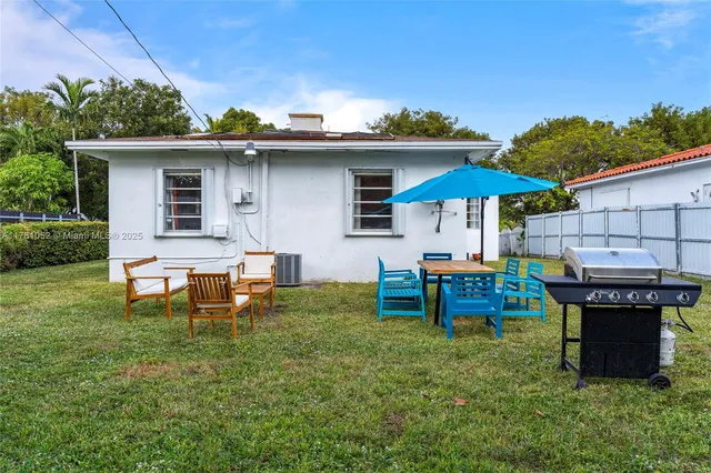 a backyard of a house with table and chairs