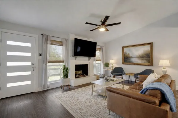 a living room with furniture a fireplace and a flat screen tv