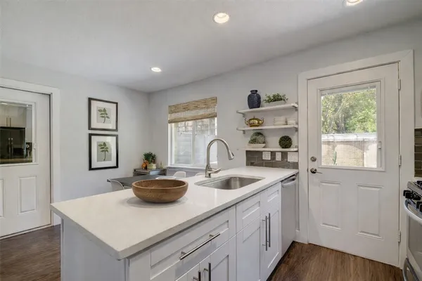 a kitchen with sink a window and cabinets