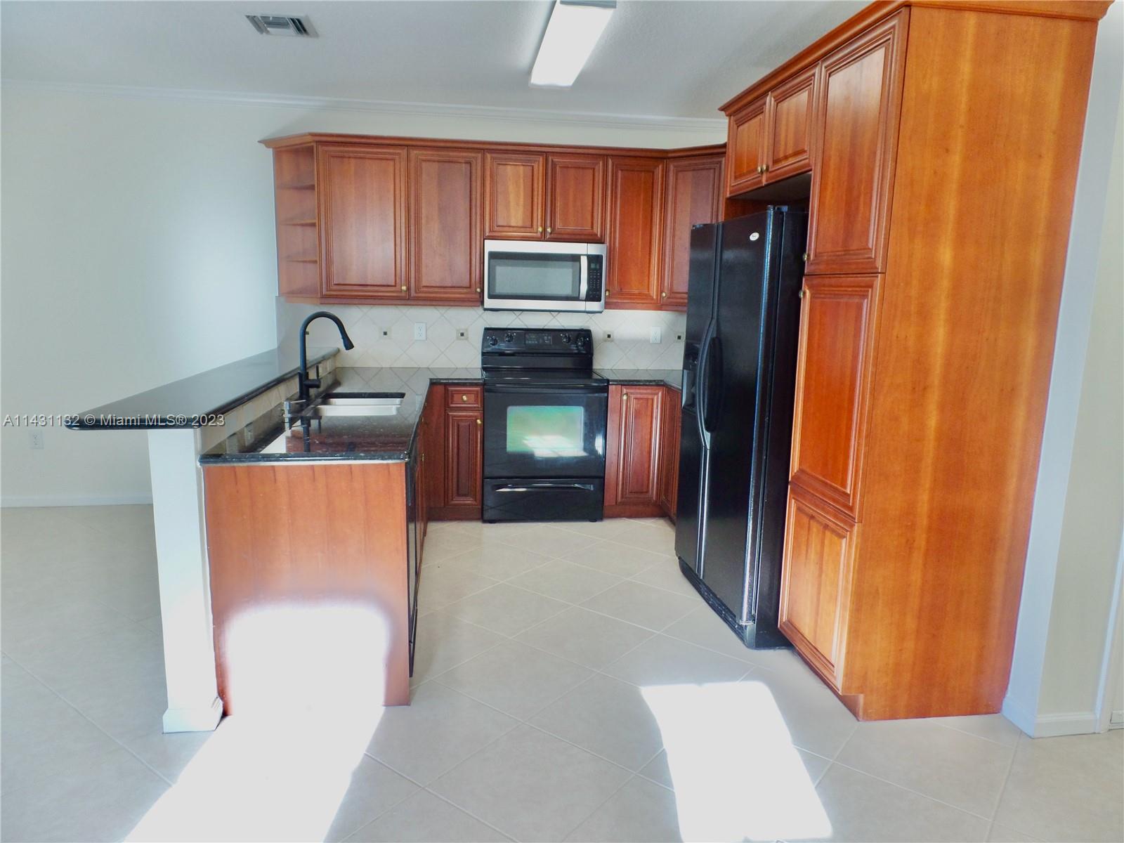 4744 Southwest 165th Avenue, Unit 4744 Miramar, FL 33027 - Photo 3 of 34 a kitchen with stainless steel appliances granite countertop a refrigerator and a sink
