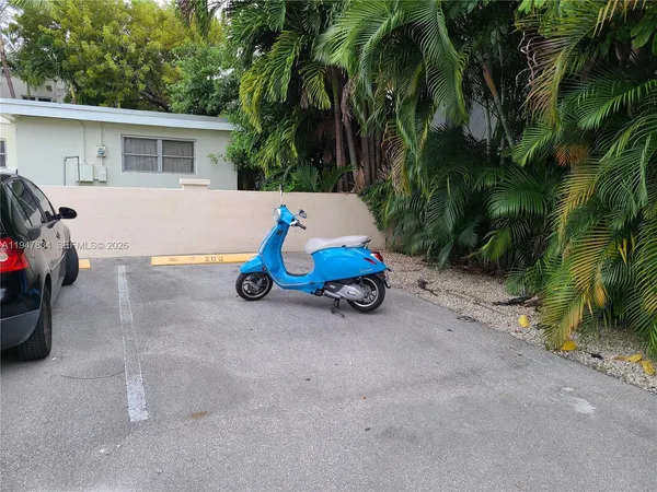 a view of backyard with a car parked beside it