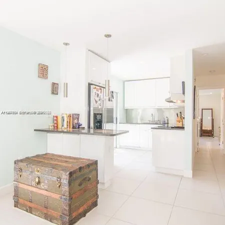 a living room with stainless steel appliances kitchen island granite countertop a stove and a sink