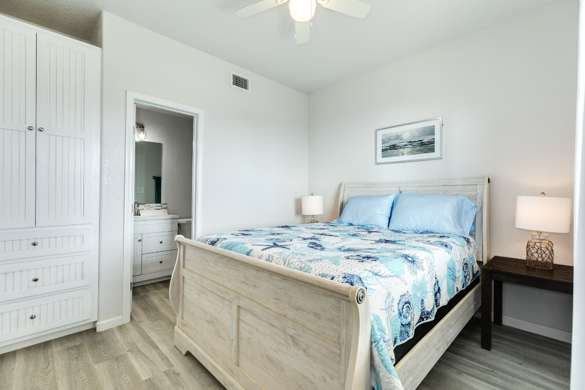 116 Howard Avenue, Unit G Surfside Beach, TX 77541 - Photo 13 of 31 a bedroom with a bed and a chandelier