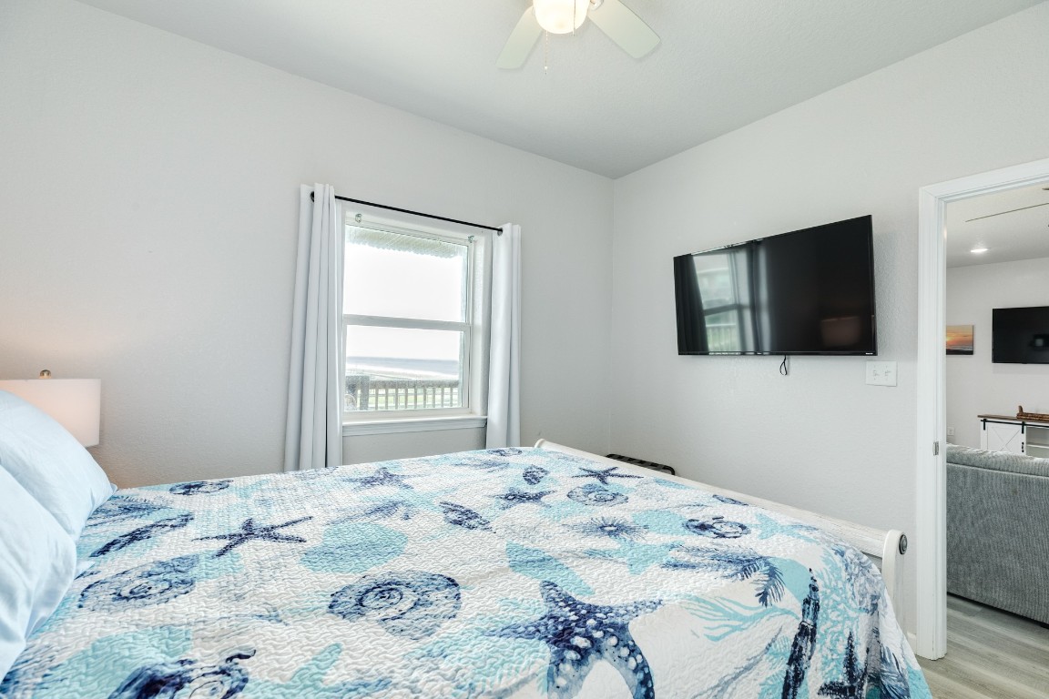 116 Howard Avenue, Unit G Surfside Beach, TX 77541 - Photo 14 of 31 a bedroom with a bed and a flat screen tv