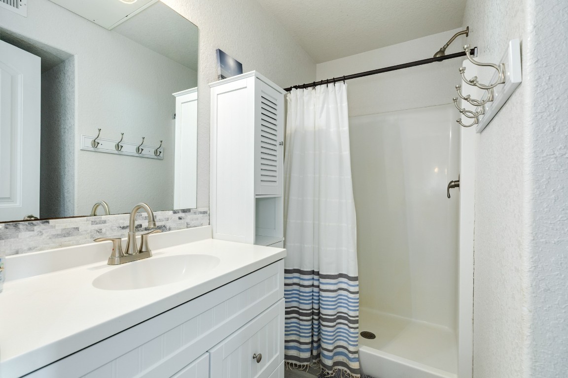 116 Howard Avenue, Unit G Surfside Beach, TX 77541 - Photo 18 of 31 a bathroom with a shower and a sink a mirror
