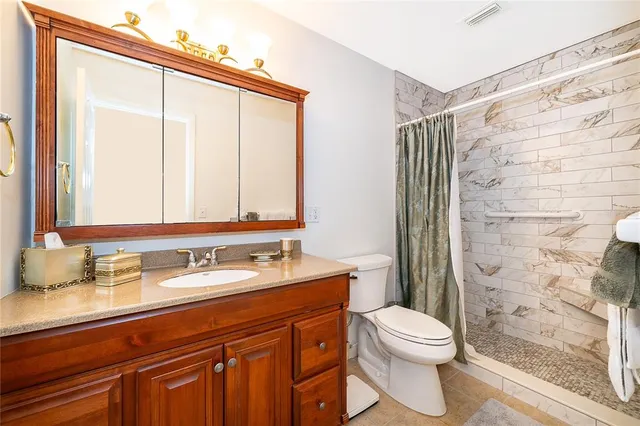 a bathroom with a granite countertop sink toilet and shower