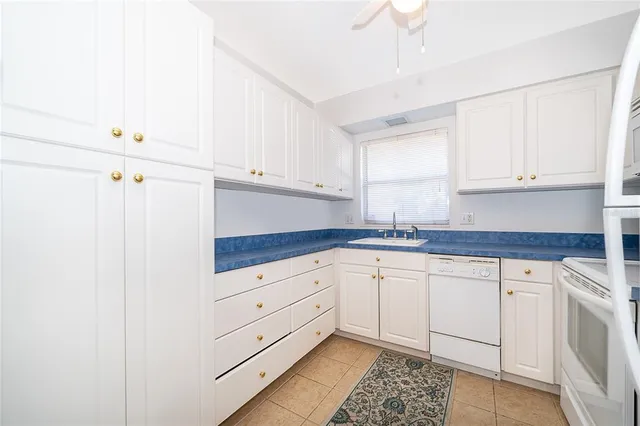 a kitchen with granite countertop white cabinets and white appliances
