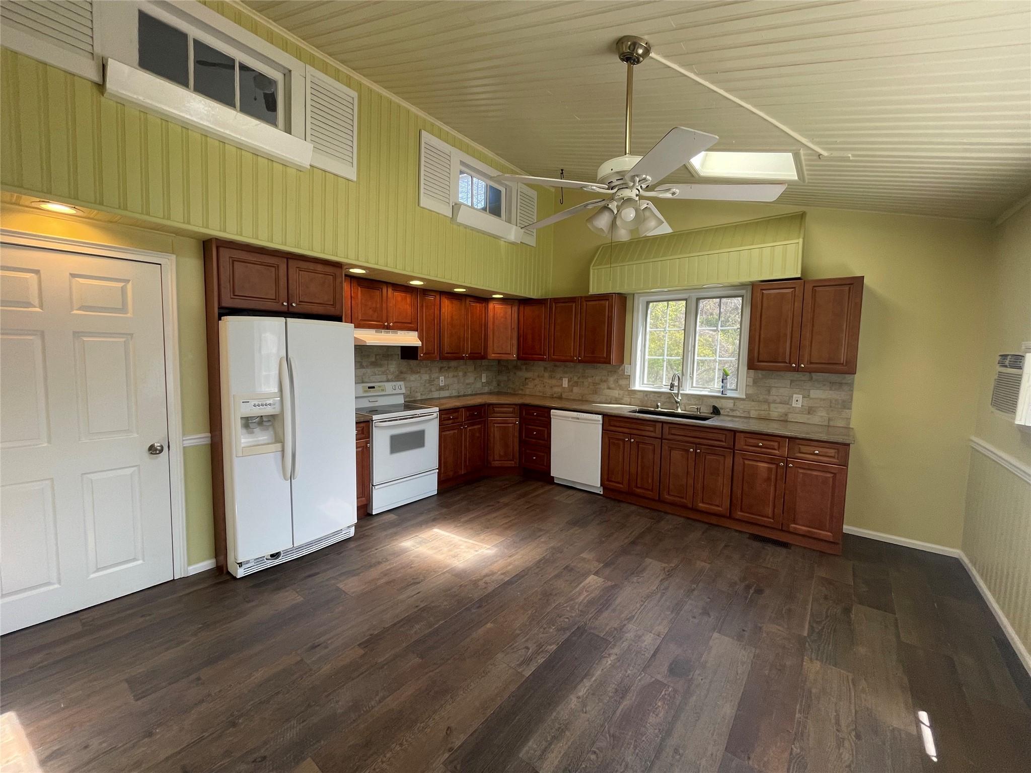 496 North Country Road St. James, NY 11780 - Photo 4 of 17 a kitchen with stainless steel appliances a sink and wooden floors