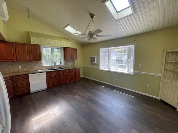 a kitchen with granite countertop wooden floors granite counter tops and a window