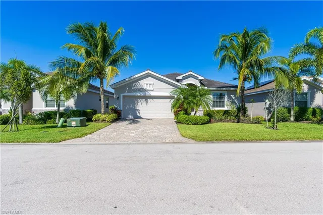 a front view of a house with a yard and potted plants