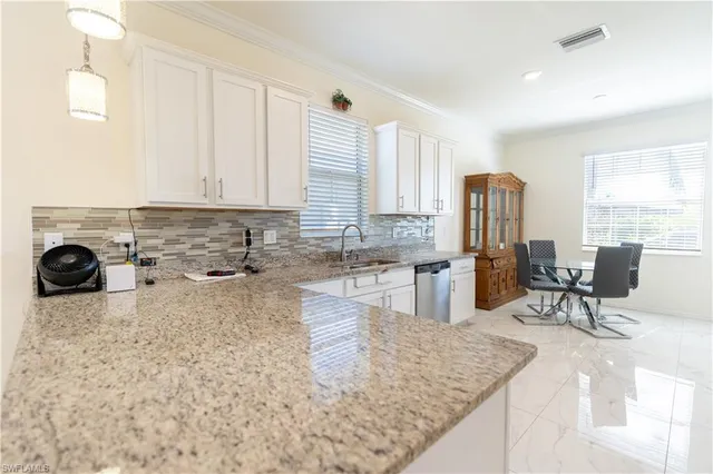a kitchen with stainless steel appliances granite countertop a sink refrigerator and cabinets