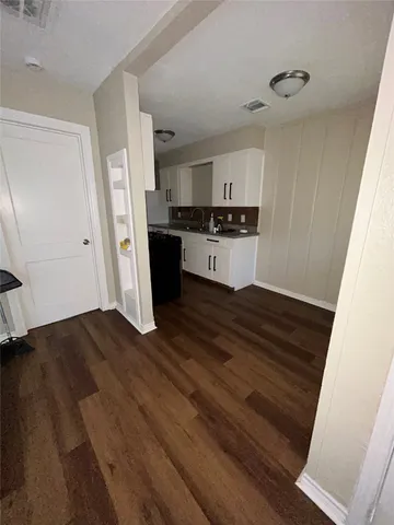 a kitchen with a refrigerator and white cabinets