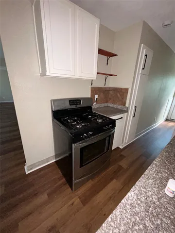 a kitchen with granite countertop a stove and a refrigerator
