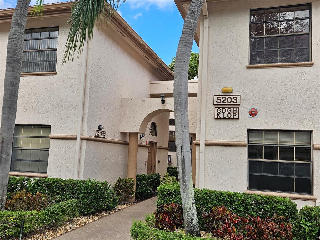5203 Europa Drive, Unit G Boynton Beach, FL 33437 - Photo 2 of 29 a front view of a house with a yard