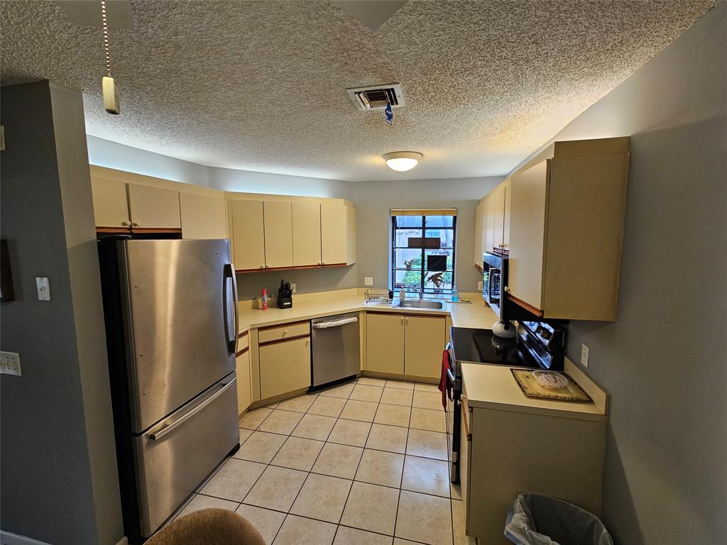 5203 Europa Drive, Unit G Boynton Beach, FL 33437 - Photo 6 of 29 a kitchen with stainless steel appliances granite countertop a refrigerator sink and microwave