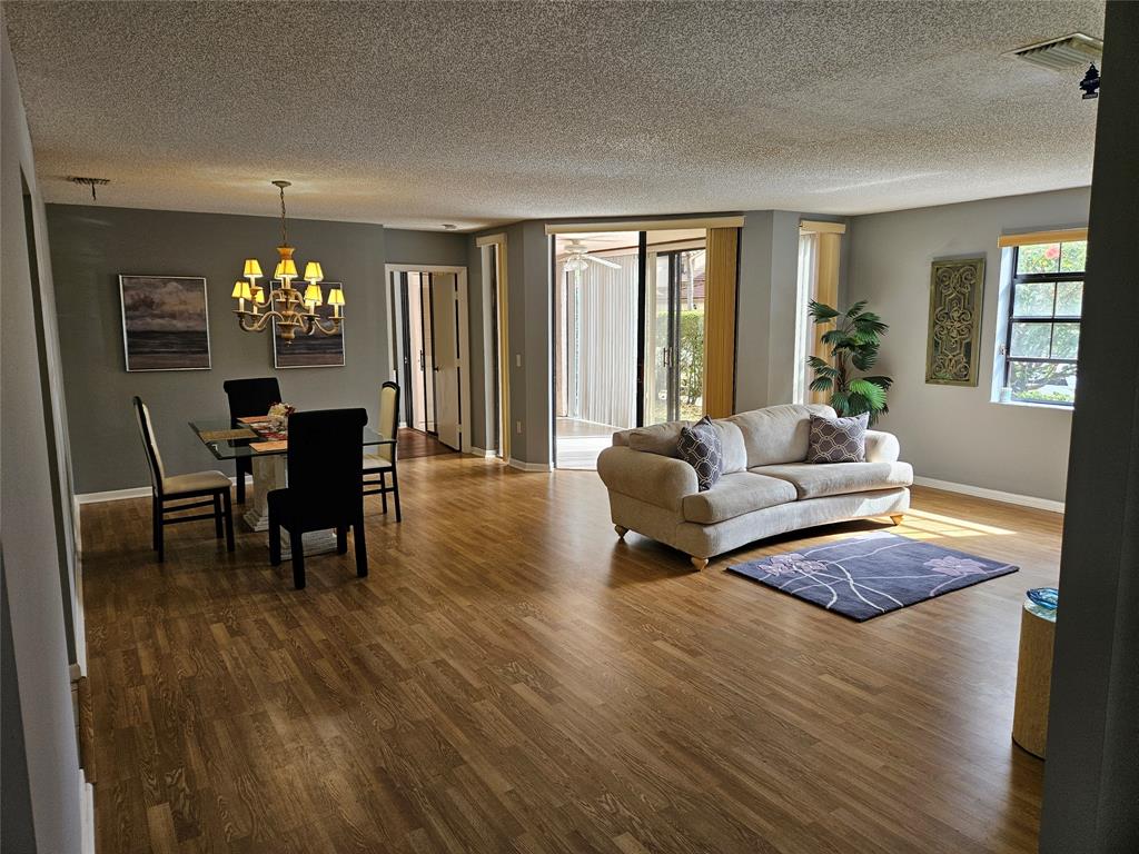 5203 Europa Drive, Unit G Boynton Beach, FL 33437 - Photo 8 of 29 a living room with furniture and a chandelier