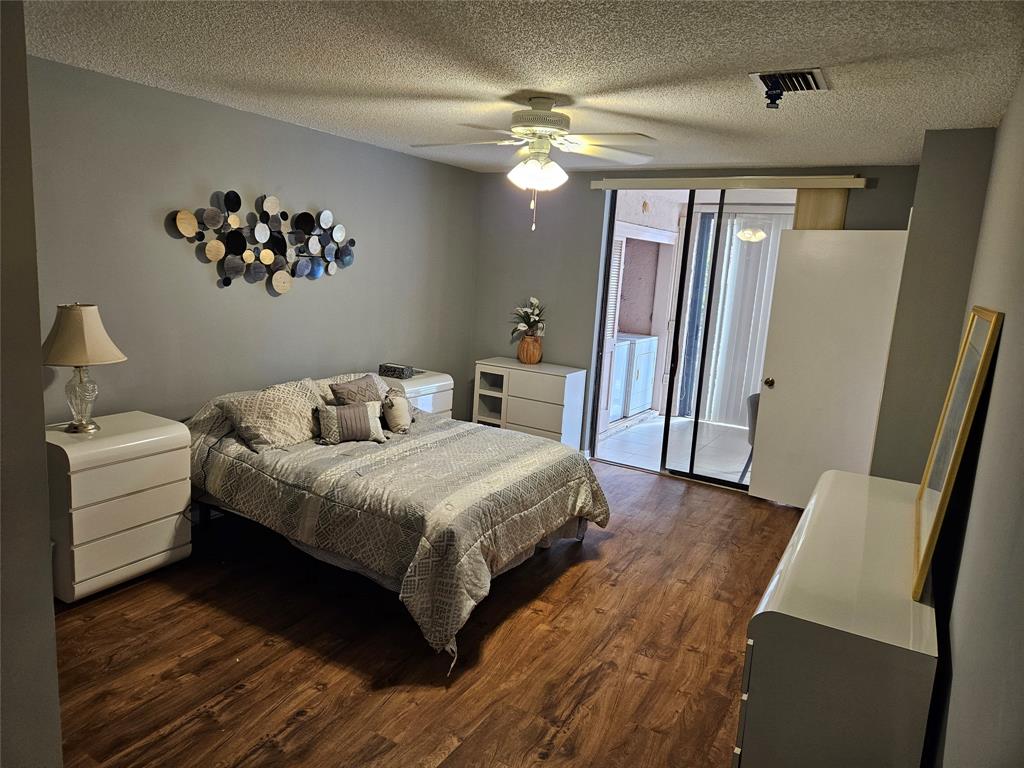 5203 Europa Drive, Unit G Boynton Beach, FL 33437 - Photo 10 of 29 a bedroom with a large bed and a chandelier