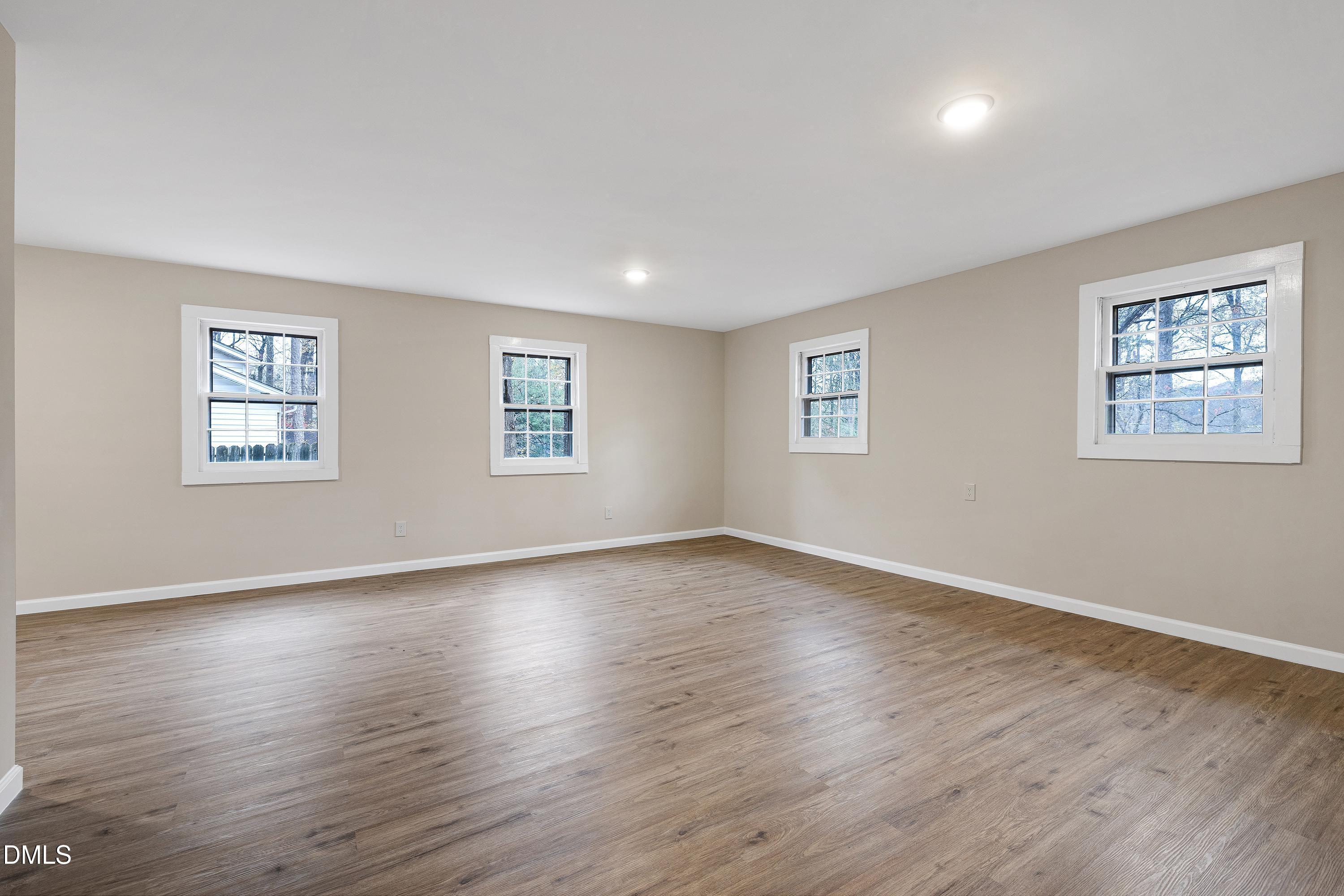 7812 Hemlock Court Raleigh, NC 27615 - Photo 18 of 25 a view of an empty room with wooden floor and a window