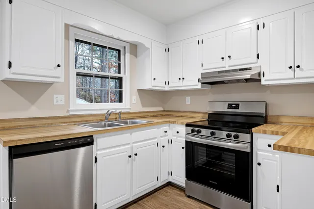 a kitchen with stainless steel appliances white cabinets and a stove a sink