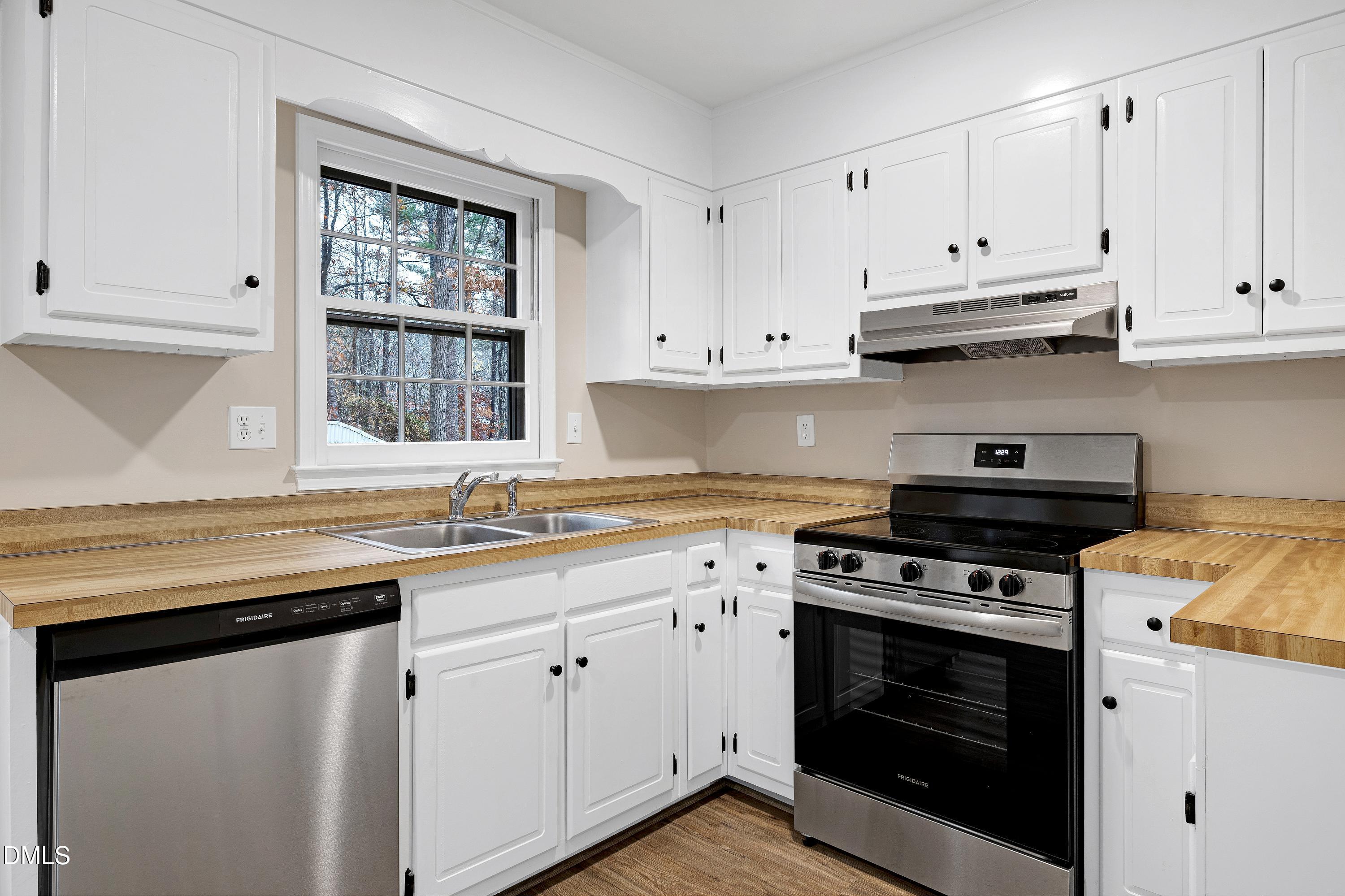 7812 Hemlock Court Raleigh, NC 27615 - Photo 2 of 25 a kitchen with stainless steel appliances white cabinets and a stove a sink