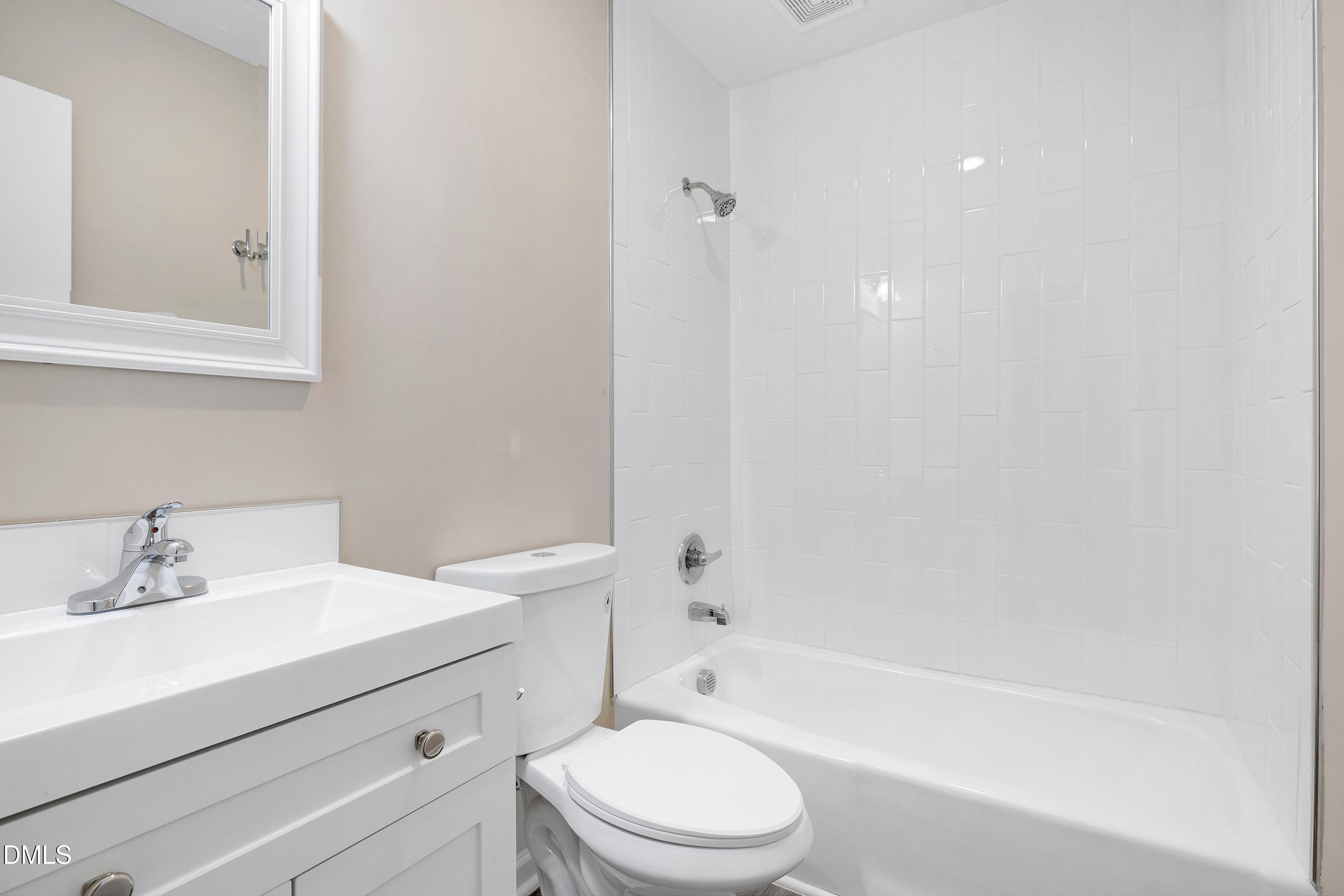 7812 Hemlock Court Raleigh, NC 27615 - Photo 7 of 25 a bathroom with a bathtub shower sink vanity mirror and toilet