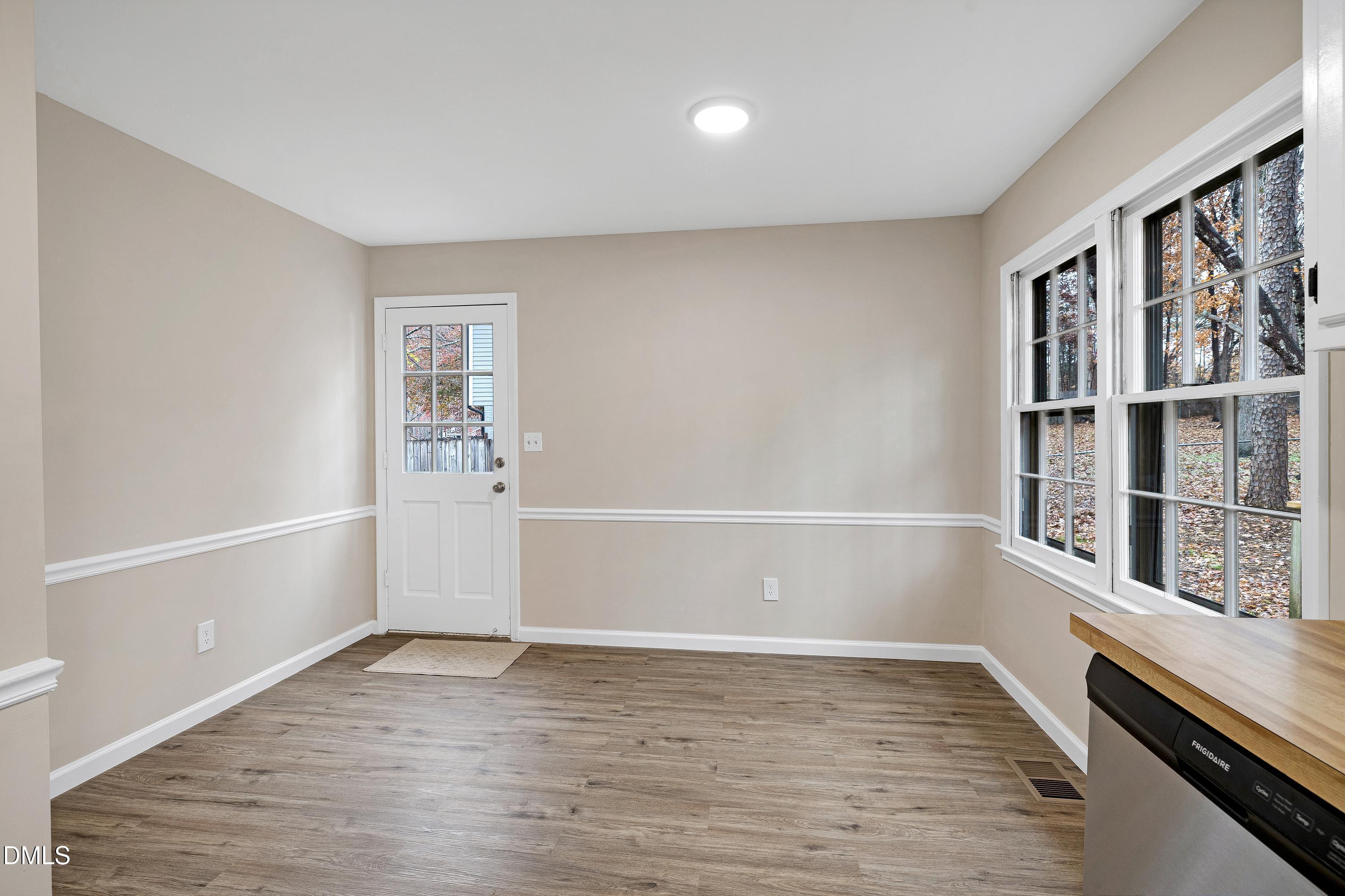 7812 Hemlock Court Raleigh, NC 27615 - Photo 9 of 25 a view of an empty room with wooden floor and a window