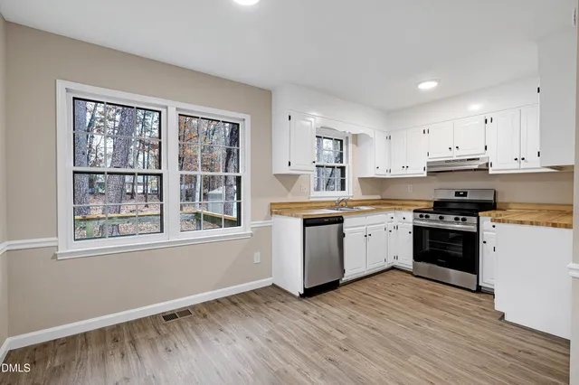 a kitchen with granite countertop a stove top oven sink and cabinets