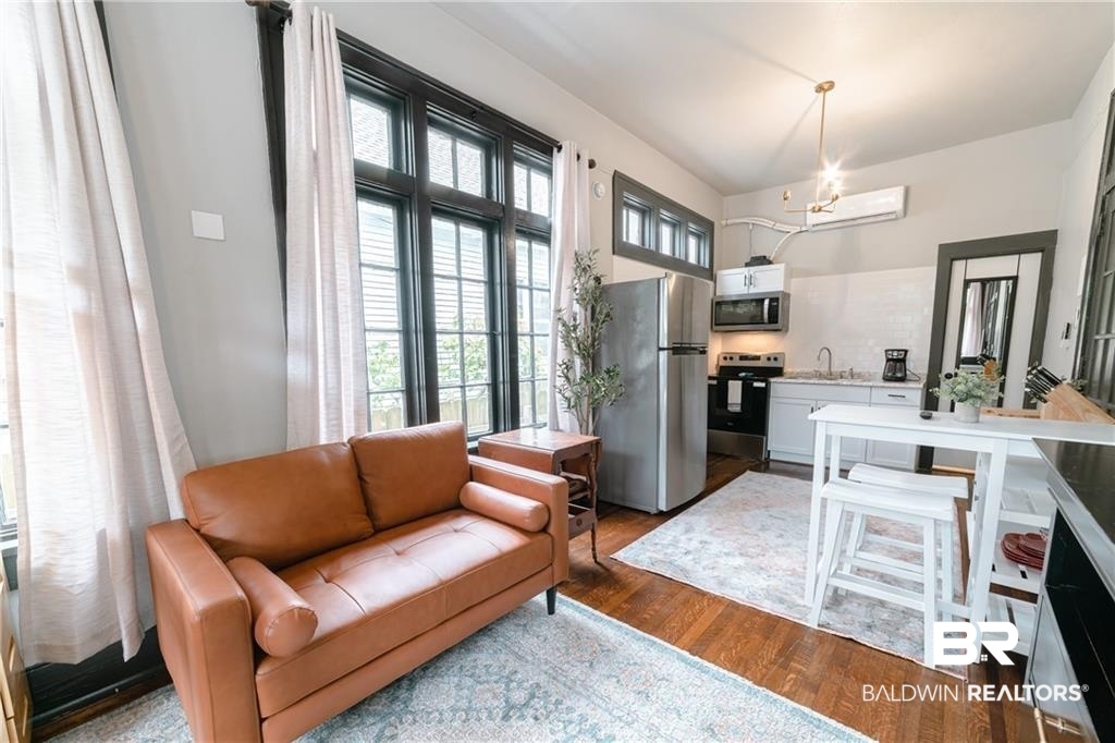 207 Michigan Avenue Mobile, AL 36604 - Photo 11 of 31 Living room with dark wood finished floors and suspended lighting