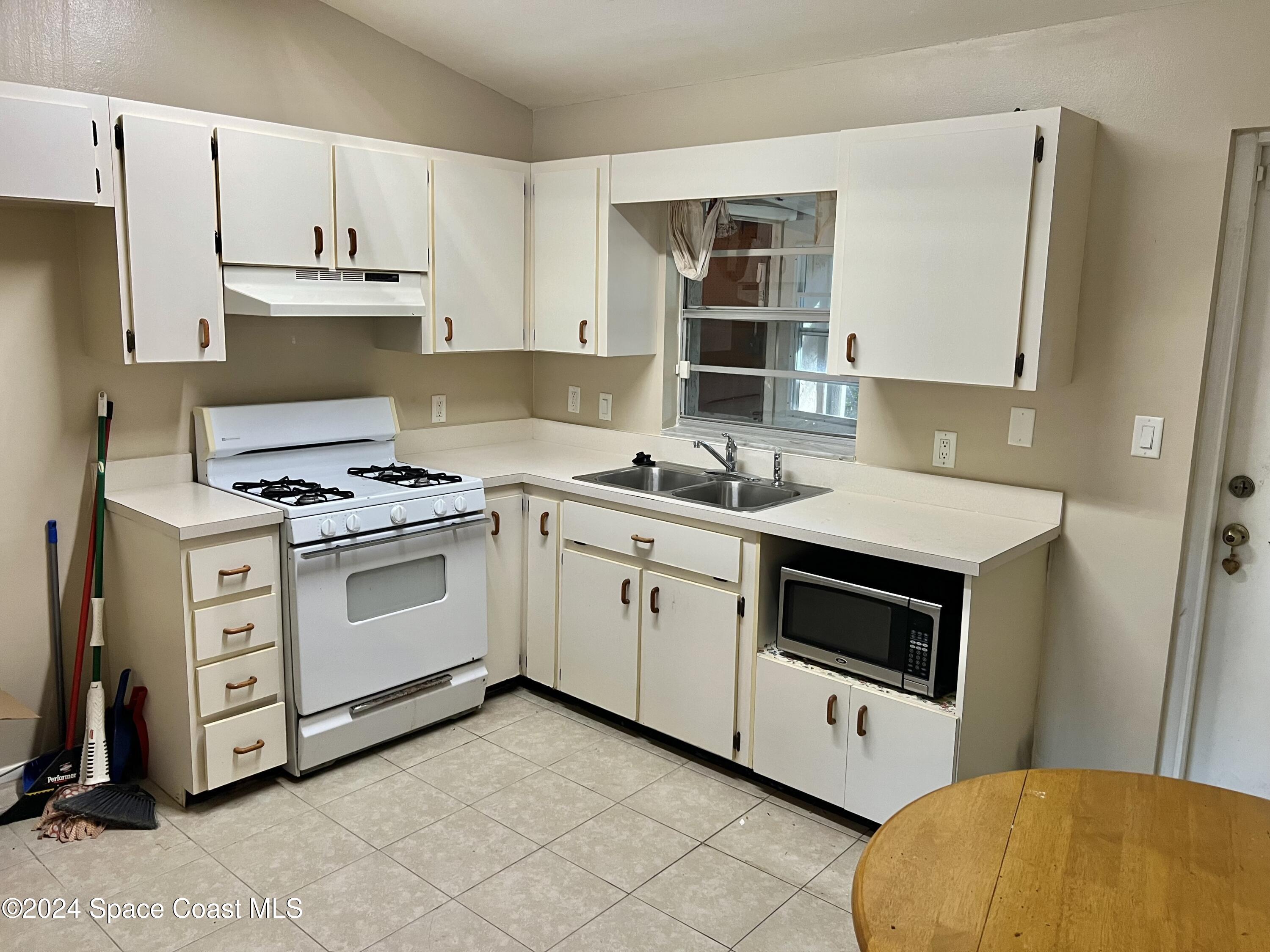 3225 Murrell Road, Unit 12 Rockledge, FL 32955 - Photo 6 of 14 a kitchen with cabinets appliances and a window
