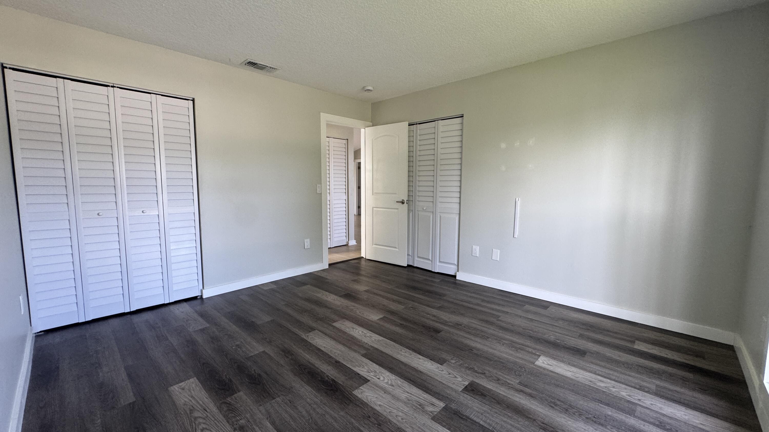 8395 Garden Gate Place Boca Raton, FL 33433 - Photo 9 of 35 a view of an empty room with wooden floor and a window