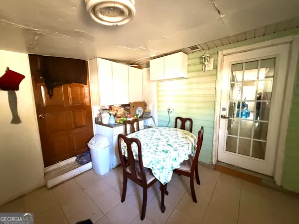 a view of a refrigerator in kitchen and an empty room