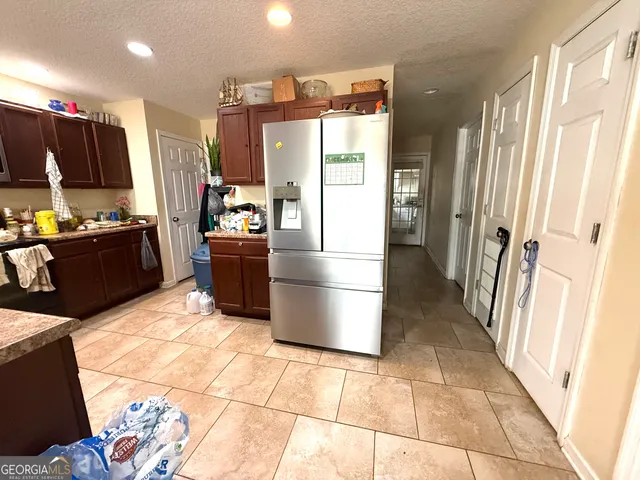 a kitchen with stainless steel appliances kitchen island granite countertop a refrigerator and a stove