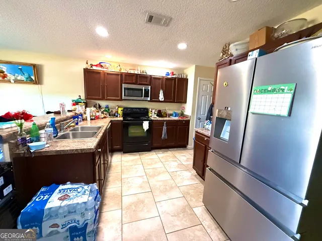a kitchen with a stove a sink dishwasher and a microwave oven with cabinets