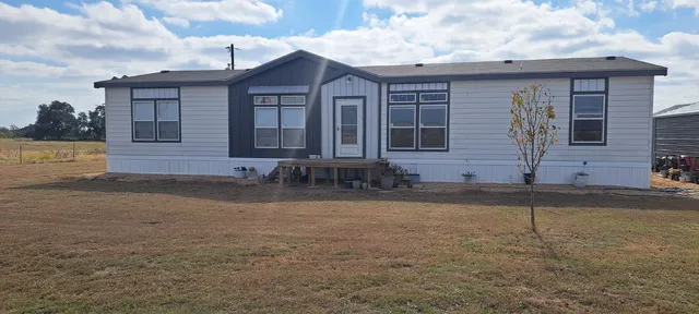 a kitchen with kitchen island granite countertop a sink cabinets stainless steel appliances and a large window