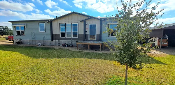 a view of a house with backyard and sitting area