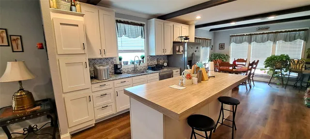 a kitchen with stainless steel appliances granite countertop a sink a stove and a refrigerator