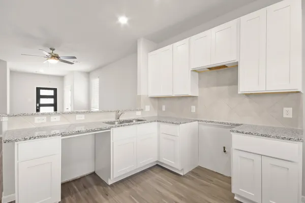 a kitchen with a sink cabinets and wooden floor