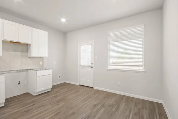 a view of a kitchen with wooden floor and windows