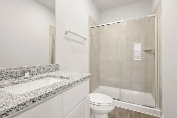 a bathroom with a granite countertop sink toilet and shower