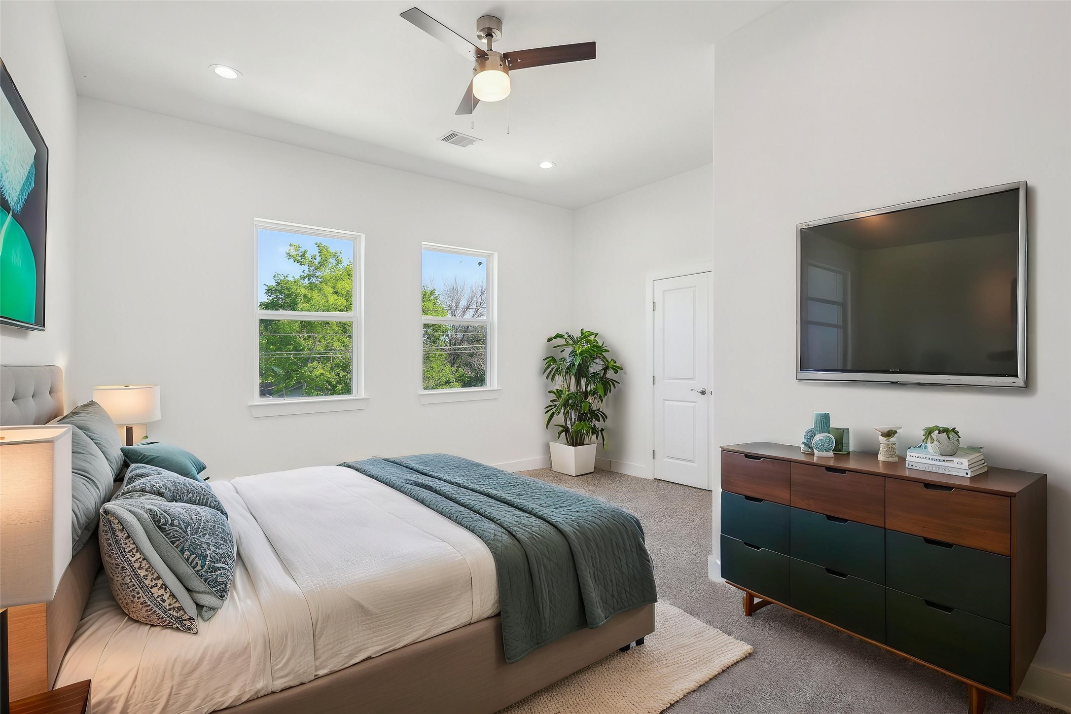 7358 Guadalcanal Road, Unit B Houston, TX 77033 - Photo 3 of 35 Bright bedroom with ceiling fan, large windows, neutral walls, and virtual staging with bed, dresser, and wall-mounted TV.