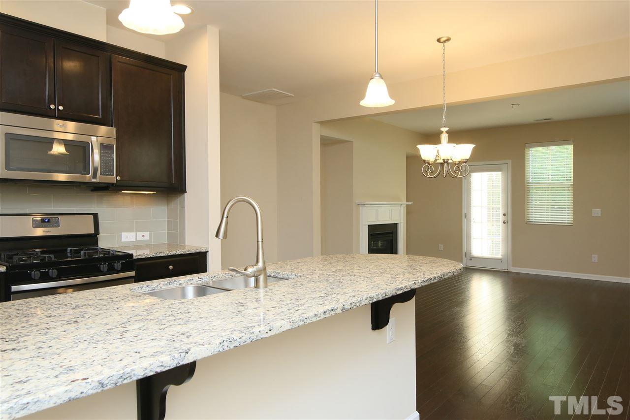 728 Wickham Ridge Road Apex, NC 27539 - Photo 2 of 21 a kitchen with stainless steel appliances granite countertop a sink a microwave a stove and a wooden floors