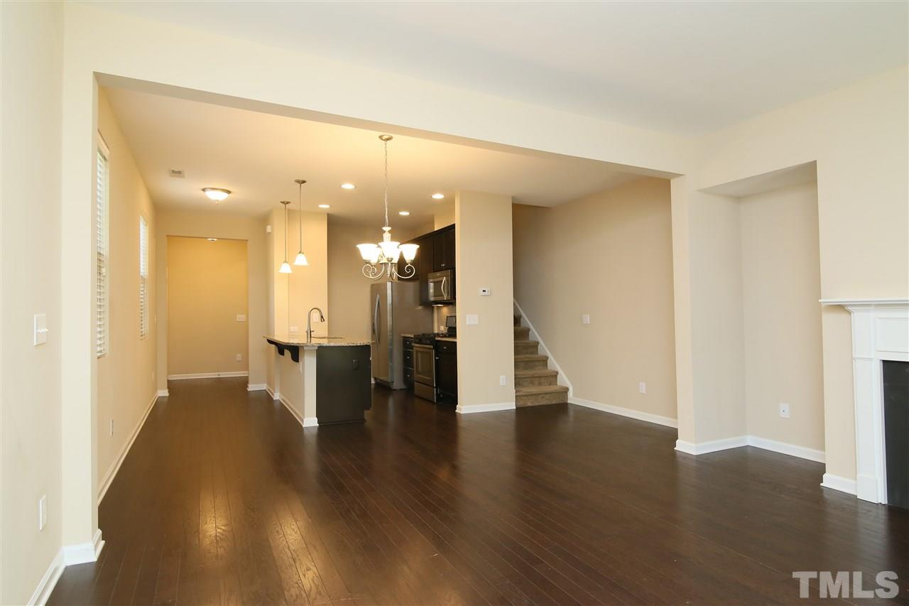 728 Wickham Ridge Road Apex, NC 27539 - Photo 3 of 21 a view of a big room with wooden floor and a kitchen