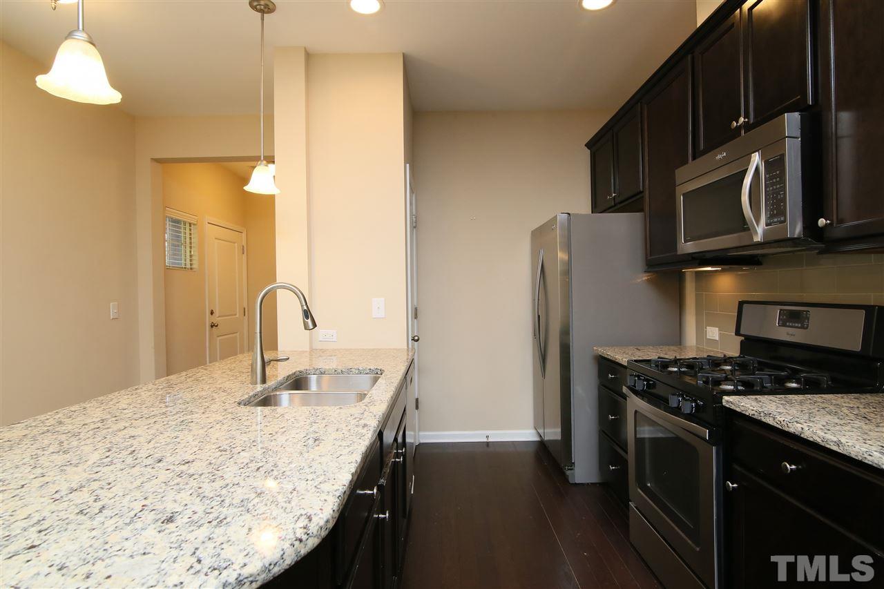 728 Wickham Ridge Road Apex, NC 27539 - Photo 5 of 21 a kitchen with stainless steel appliances granite countertop a sink stove and refrigerator