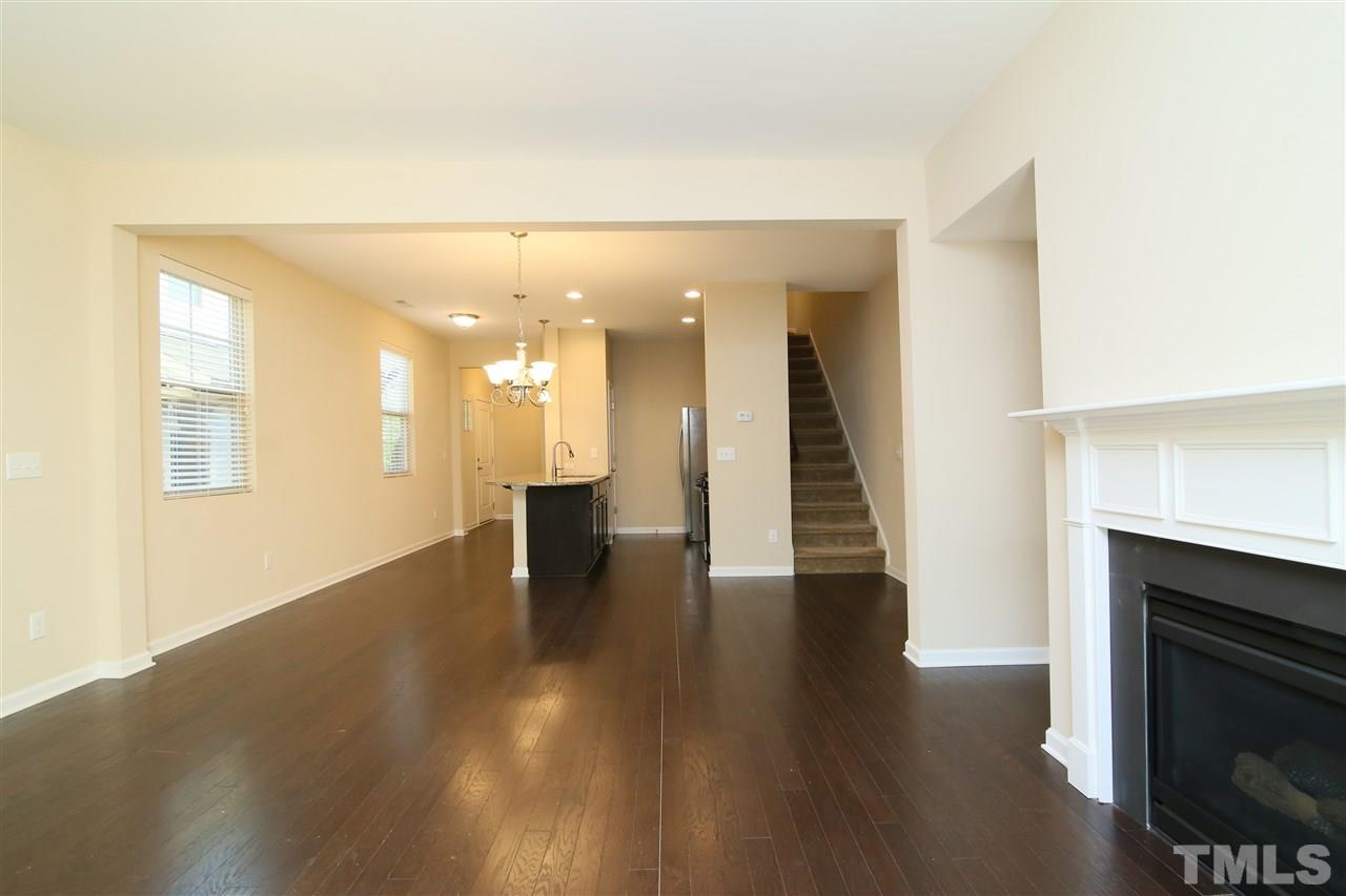 728 Wickham Ridge Road Apex, NC 27539 - Photo 8 of 21 a view of a hallway with wooden floor and a fireplace
