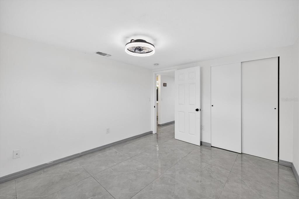 7814 Birchwood Drive Port Richey, FL 34668 - Photo 11 of 33 an empty room with a fan & a window