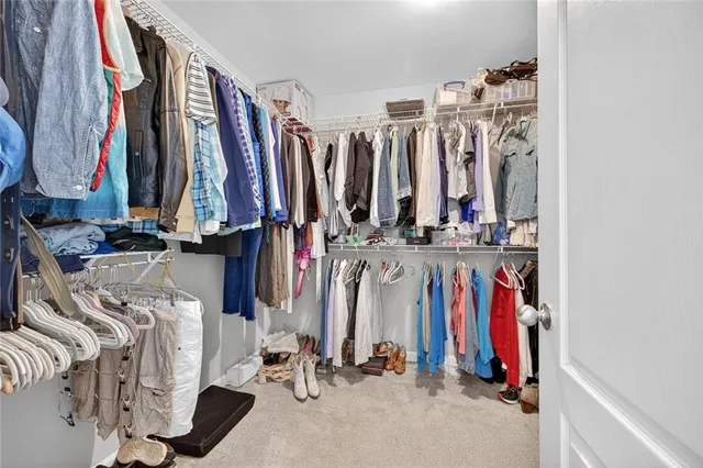 a view of walk in closet with clothes
