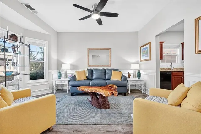 a living room with furniture kitchen view and a large window